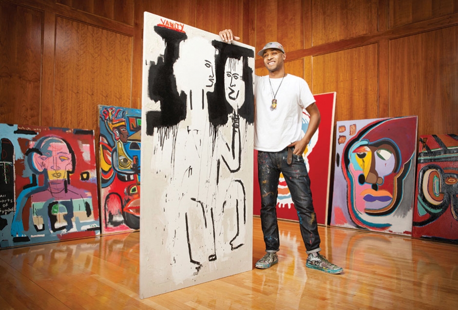 Asa Jackson stands before his artwork wearing his own designs.