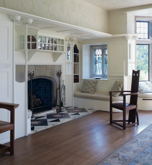 Mackay Hugh Baillie Scott, Blackwell, 1900, Bowness-on-Windermere, Cumbria, England. Positioned at the brow of a hill, the house has a masculine feel, but the light, tranquil drawing room offers a distinct contrast. Its inglenook fireplace, set amid ornate white plasterwork, becomes a carefully conceived room within a room. Photograph by Richard Powers, as featured in “The Iconic House: Architectural Masterworks Since 1900.” Courtesy Thames & Hudson.