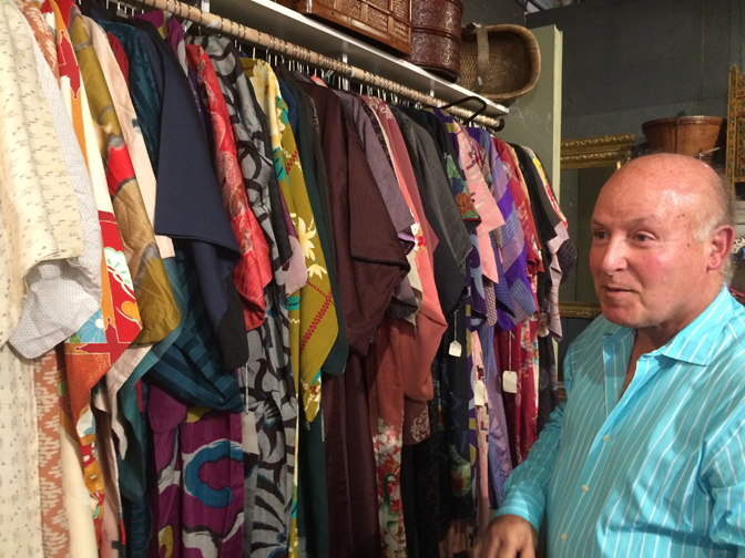 Randolph Rose alongside a collection of Japanese kimonos.