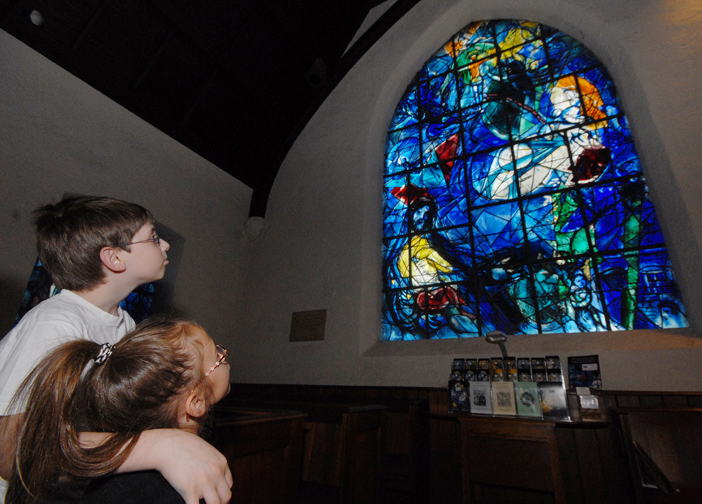 Young students in Historic Hudson Valley's educational programs gaze at “The Good Samaritan” window at the Union Church of Pocantico Hills. Photograph by Bryan Haeffele. Courtesy Historic Hudson Valley.