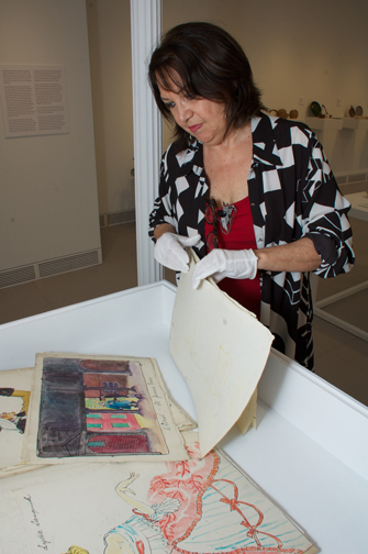 Curator Carinda Swann examines Russel Wright illustrations at the Garrison Art Center.