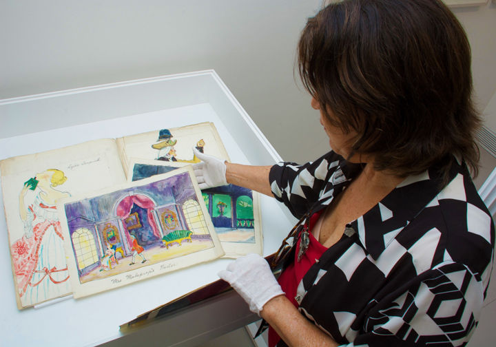Curator Carinda Swann examines Russel Wright theatrical drawings at the Garrison Art Center.