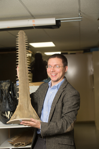 Daniel Ksepka stands with a large fossil. Photograph by John Rizzo.