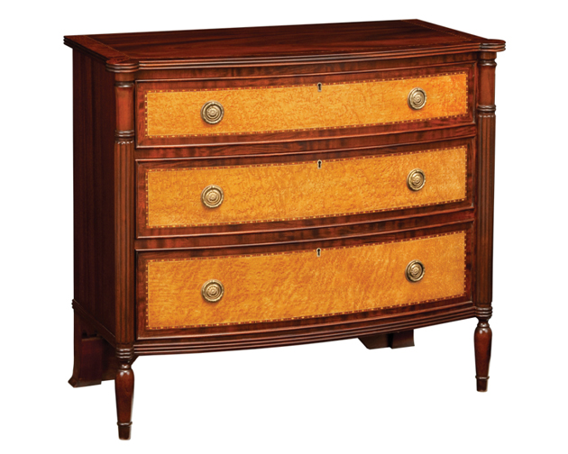 Bow front chest with top with inset ornamental band and cross banded mahogany inlay. 
