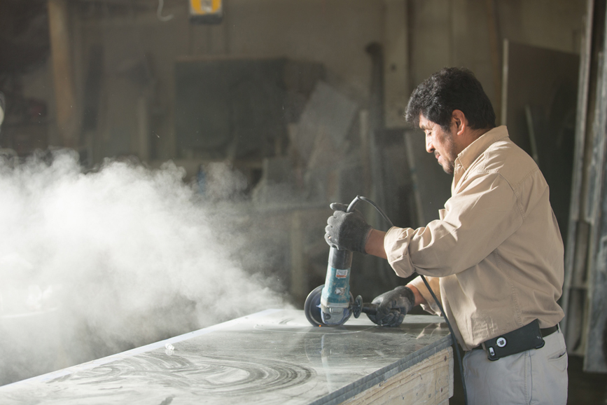 Oscar Reyes, owner of Westchester Granite Inc., The Marble & Granite Works Co., is hard at work in his Mamaroneck workshop. Photo from October 2015. Photograph by John Rizzo.