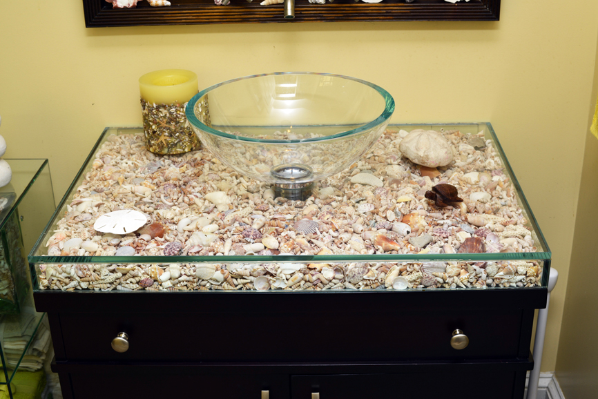 A bathroom sink showcasing family keepsakes: one of George Distefano's many glass touches in the couple's North Salem home. Maria Bilotta and George Distefano. Photograph by Bob Rozycki.