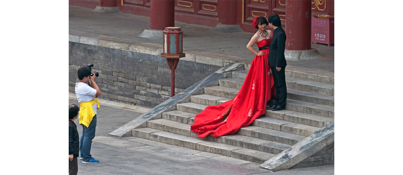 The bride wears traditional red as she poses with her groom on the steps of the Temple of Heaven in Beijing. Photograph by Daniel Case.