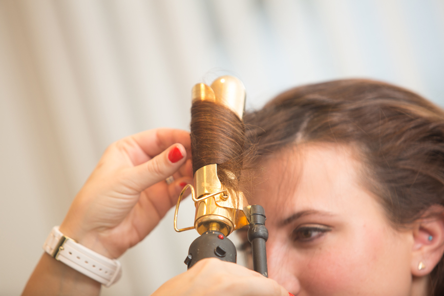 Rosemaria Brown beautifies Gennifer's hair using a curling iron for a voluminous, finished look.