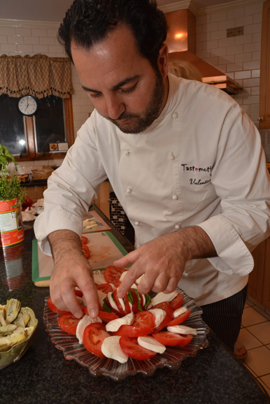 George Valentino Pestritu prepares an antipasto platter of tomatoes, fresh mozzarella and basil. Photograph by Bob Rozyki.