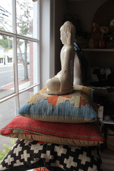 Porcelain Buddha atop kilim pillows in Mama Jane’s Global Boutique. Photograph by Elizabeth Kirkpatrick for Mama Jane’s Global Boutique.