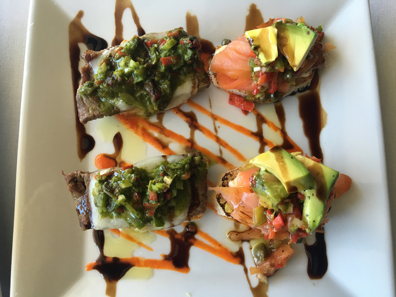From left: grilled strip steak crostini with Manchego cheese and chimichurri sauce and a smoked wild salmon crostini with Manchego cheese and a Mediterranean vegetable relish. Photograph by Danielle Renda.