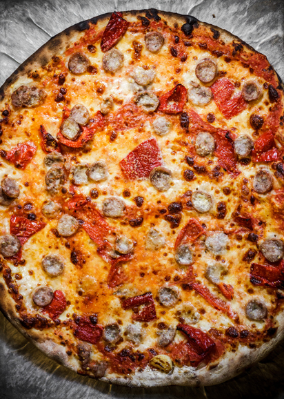 Pizza topped with tomato sauce, sausage and roasted red peppers. Photograph courtesy Thomas McGovern Photography.