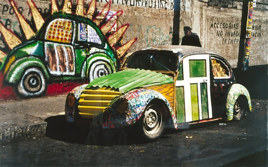 Betsabeé Romero, “Ceci n’est pas une voiture I (This is not a Car),” a 2000 color photograph from the installation “Auto-construido,” plays on the René Magritte painting “Ceci n’est pas une pipe,” which explores the tension between art and reality. 10 ½ x 17 3/8 inches, 1/5. Collection of the Friends of the Neuberger Museum of Art, Purchase College, State University of New York. Gift of the artist. ©Betsabeé Romero. 