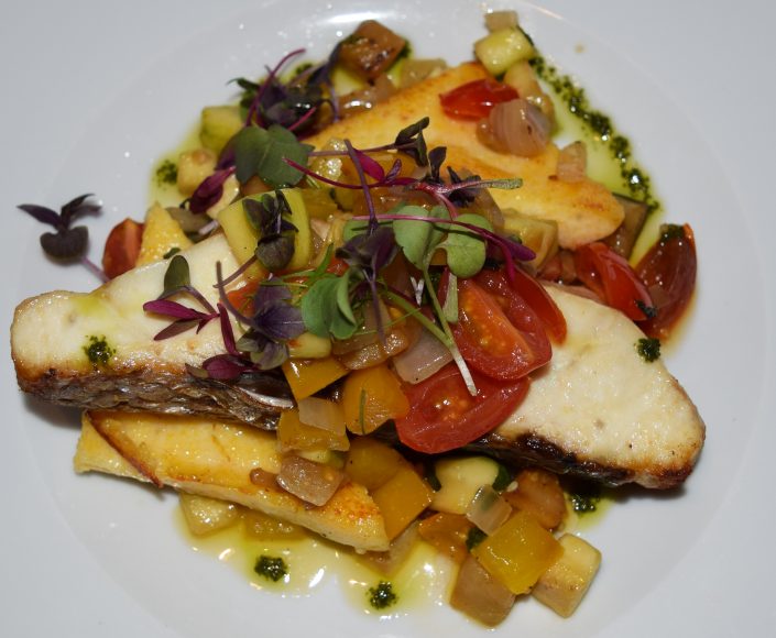 A striped bass entrée at Dere Street Restaurant served with polenta and a vegetarian ratatouille. Photograph by Aleesia Forni.