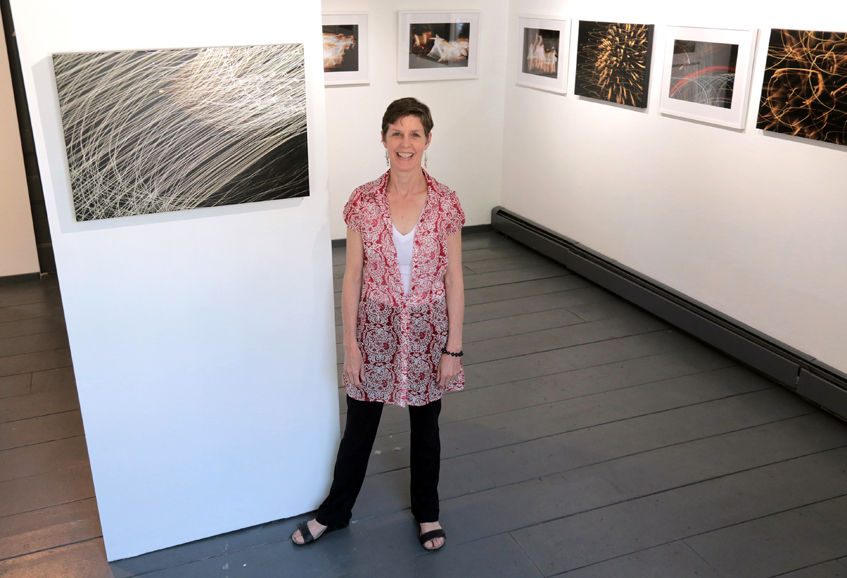Ellen Crane, with a selection of her work at Gallery 66 NY in Cold Spring. Photograph by Doug Schneider Photography.