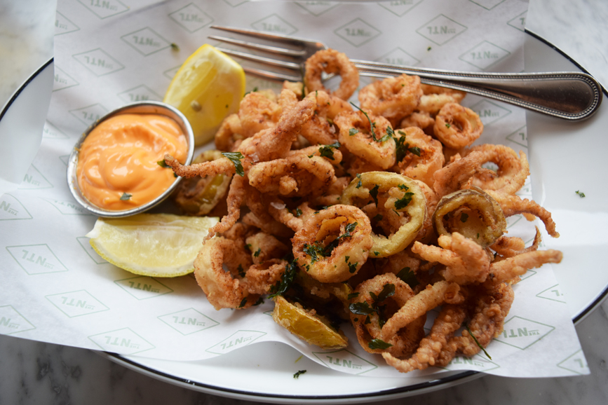 A basket of fried calamari and spicy pickled jalapeño slices at The National. Photograph by Aleesia Forni.