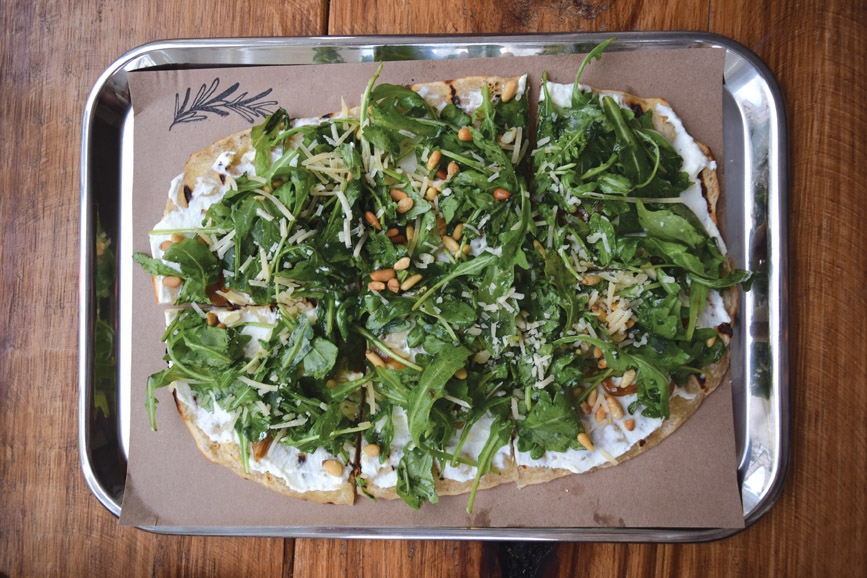 The Ella flatbread plate, topped with ricotta, baby arugula, Parmesan and toasted pine nuts. Photograph by Aleesia Forni.