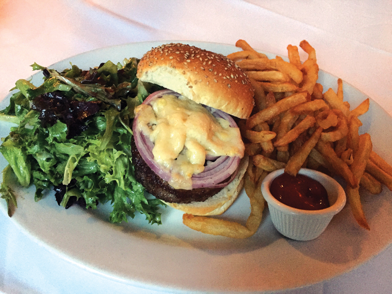 Generous portions of greens and French fries bookend a Kobe beef burger. Photograph by Aleesia Forni.