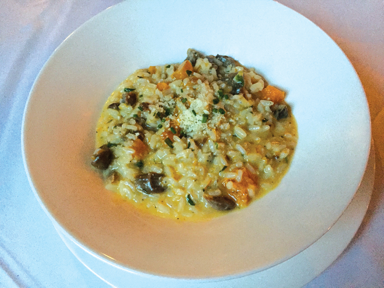 A bowl of risotto is mixed with duck confit and butternut squash. Photograph by Aleesia Forni.