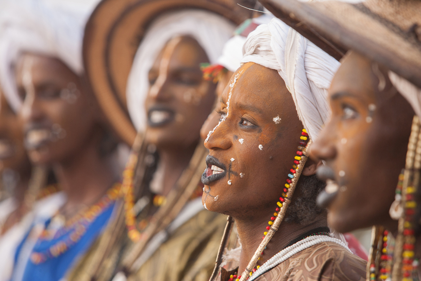 A line of men practicing their singing and exaggerated facial expressions during an afternoon practice session.