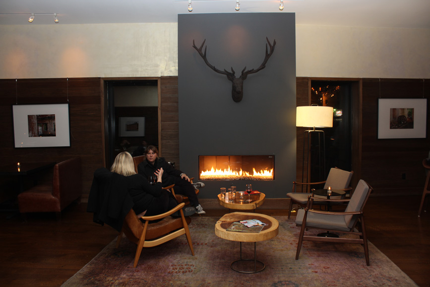 Guests sit by a fireplace in the hotel’s lounge. Photograph by Aleesia Forni.