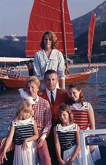 In Repulse Bay, Hong Kong, British Crown Colony, 1966. The Toppings on their motorboat on the way to board their Chinese junk (red sails in the background) for a weekend of sailing and waterskiing on the South China Seas. Susan stands in back.
Middle row: Audrey with Charlie, their pet cockatoo, who always sailed with them; Seymour, known as Top; and Karen. First row: Robin and Lesley. Courtesy Audrey and Seymour Topping.