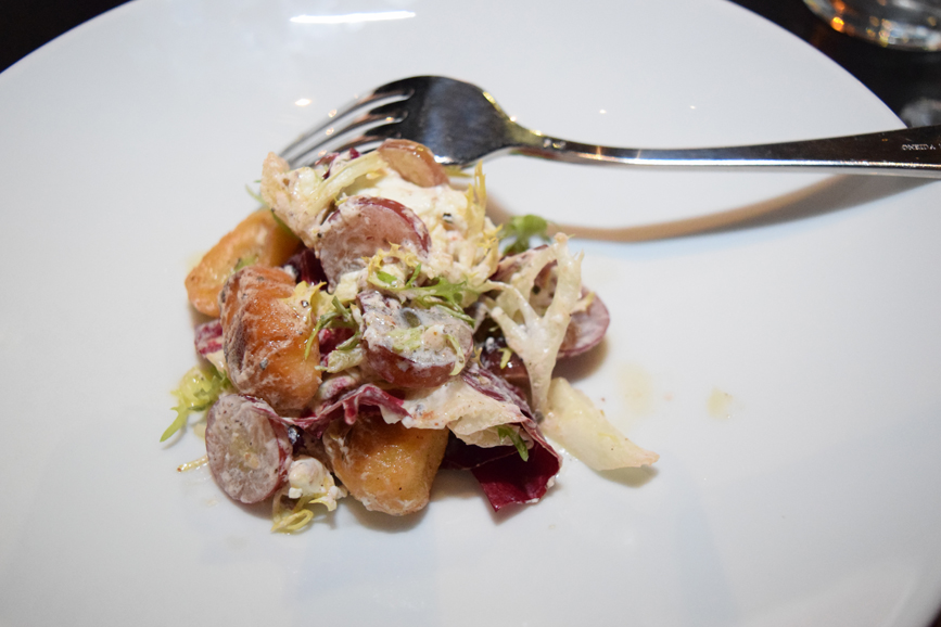 Crispy potato gnocchi salad with red grapes, goat cheese, trevisano and frisee. Photograph by Aleesia Forni. 
