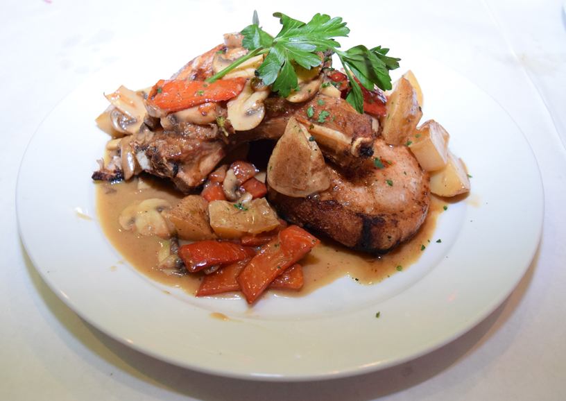 A pork chop served with mushrooms and carrots. Photograph by Aleesia Forni.