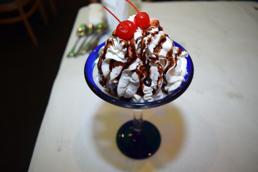 A delectable brownie sundae is topped with whipped cream and a cherry. Photograph by Aleesia Forni.