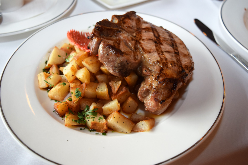 A juicy pork chop pairs perfectly with goose fat-roasted potatoes. Photograph by Aleesia Forni.