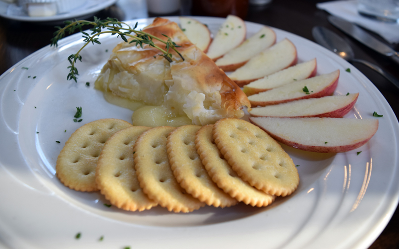 Creamy brie cheese pairs perfectly with crackers and sliced apples. Photograph by Aleesia Forni.