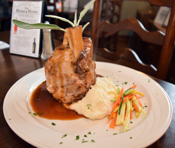 Eye-catching pork osso bucco is served with creamy mashed potatoes and julienned vegetables. Photograph by Aleesia Forni.