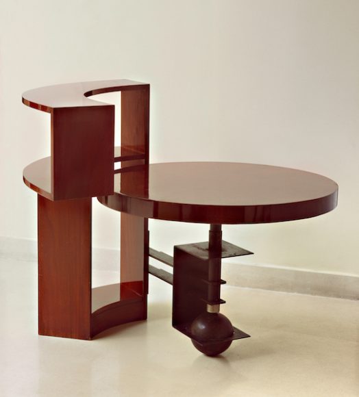 Table and bookcase (MB960), c. 1930, designed by Pierre Chareau, walnut and black patinated wrought iron; Bookcase: 36 Ω ◊ 45 º  ◊ 8 in. (92.7 ◊ 114.9 ◊ 20.3 cm); table: 23 Ω in. (59.7 cm) high, 33 æ in. (85.7 cm) in diameter.  Vallois, Paris.