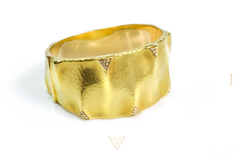An 18-karat, yellow-gold bangle featuring handmade, hammered finishing with white diamond accents, $19,000. Photograph courtesy Vendorafa.