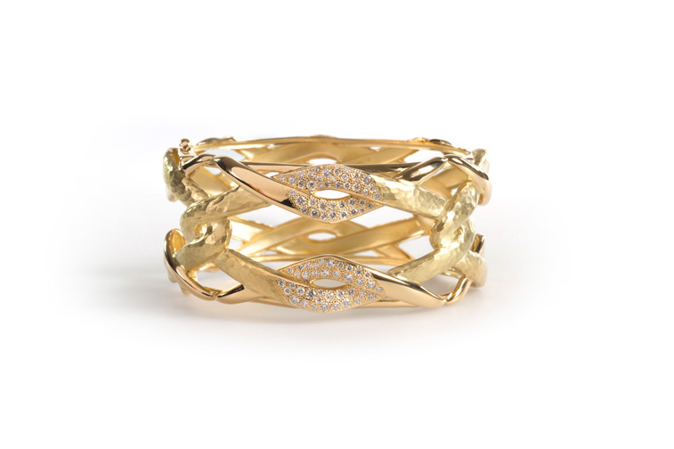 An 18-karat, yellow-gold bangle featuring twisted links with a hammered and polished finishing, delicately adorned with white diamonds, $24,000. Photograph courtesy Vendorafa.