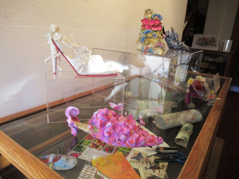 A display case at The Norfolk Library introduces patrons to the tools and materials used by Millbrook paper artist Linda Filley to create her fanciful shoes. Photograph by Mary Shustack.