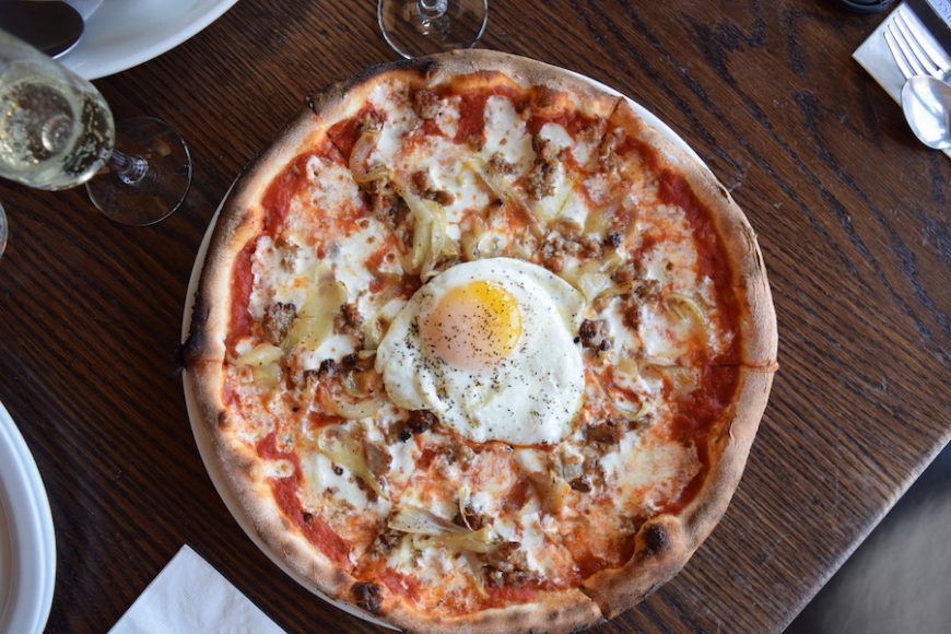 Sausage, mozzarella and onion pizza is topped with a sunny-side-up egg.