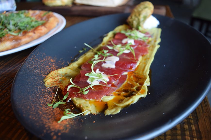 An appetizer of tuna crudo is drizzled with yuzu aioli and topped with sprouts. Photograph by Aleesia Forni.
