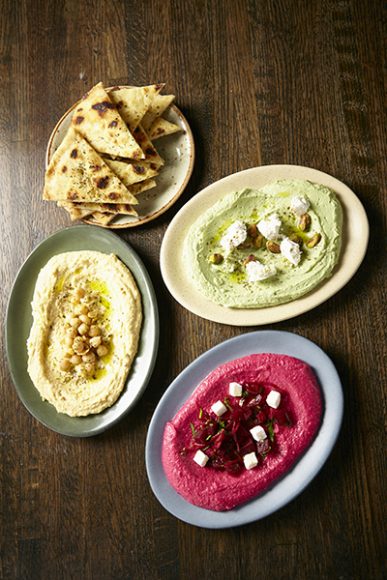From left, clockwise: grilled pita seasoned with dry oregano and sea salt; edamame pistachio dip; cannellini and beet dip; and classic hummus. Photographs courtesy The Livanos Restaurant Group.