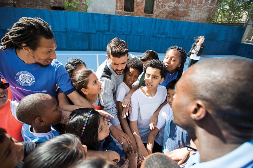 David Villa celebrating his contract extension with kids at P.S. 49 in the South Bronx. Photograph courtesy nycfc.com. 