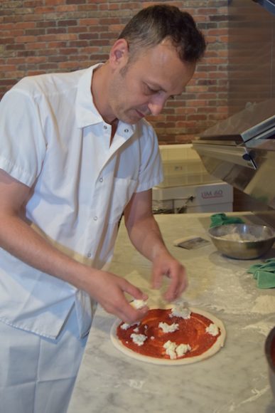 Pizza-maker Flavio Garelli whips up one of the eatery’s signature dishes, a Margherita pizza.