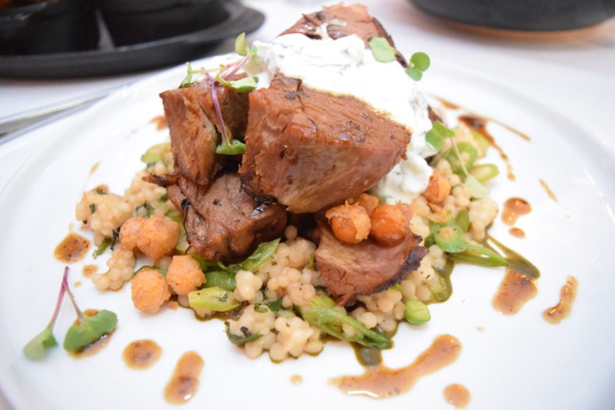 Leg of lamb is paired with couscous and topped with a creamy tzatziki sauce. Photograph by Aleesia Forni.