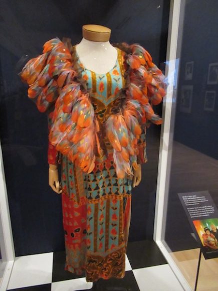 Bill Blass (1922-2002). Dress and feather trim, ca. 1970. Silk (pile velvet exterior), synthetic (lining), polychrome and gilded feathers adhered to silk. Gift of Melisande Sherman. The feather “shawl” was originally a trim at the bottom edge of the dress. Editta Sherman had it cut off and used it as a shawl. Photograph by Mary Shustack.