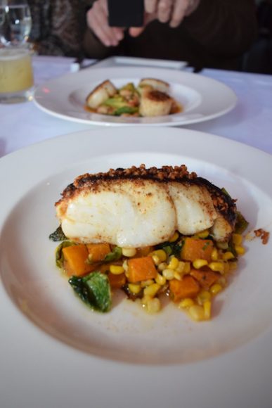 Chipotle cod sits on a bed of butternut squash, corn and Brussels sprout leaves. Photograph by Aleesia Forni.