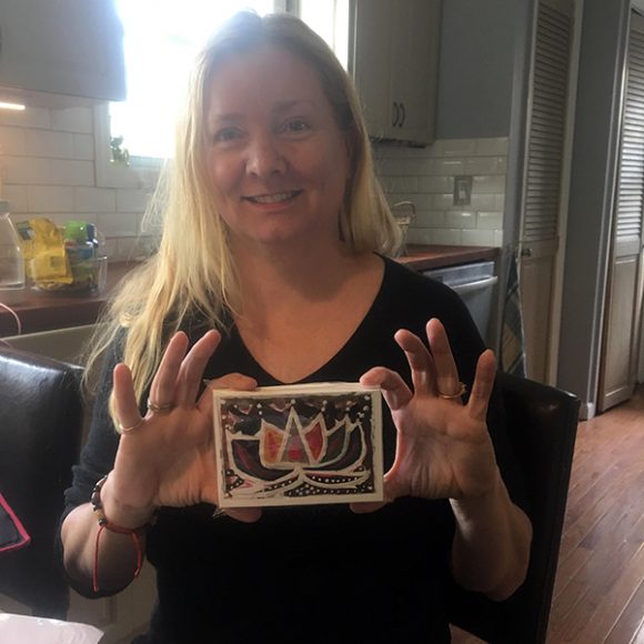 Truike Boekholt, founder of Children of the Ganges, holding a package of greeting cards featuring artwork made by the students. Photograph courtesy Children of the Ganges.