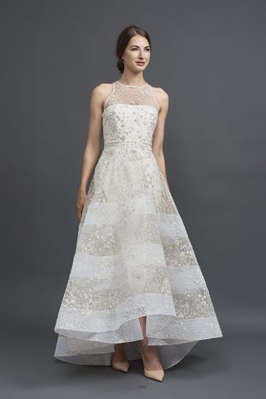 A metallic flocked tulle racer-cut bodice high-low gown in ivory/gold with a horse-hair banded skirt, $4,170. Model – Tanya Gavrilova. Photograph by Roman Makhmutov.