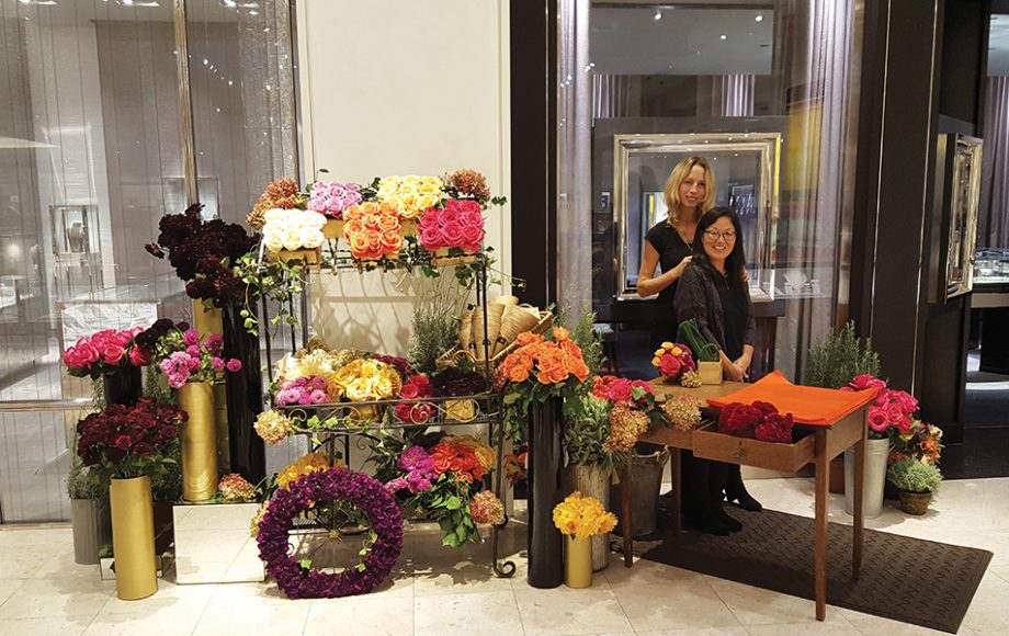 Kathi Cochran (standing) and Stefani Chisholm at their pop-up flower stand in Neiman Marcus Westchester for a recent event. Courtesy KC Creations.