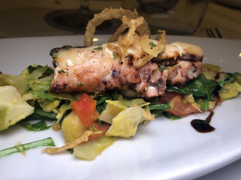 Grilled octopus with Brussels sprouts, tomatoes and a balsamic glaze.