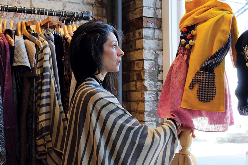 Stephanie Doucette rearranges a mannequin displaying an outfit from Petite Doucette, her children’s collection. Photograph by Danielle Renda.