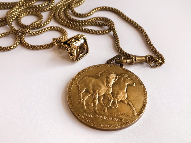 Julie Betts Testwuide uses fobs – chains originally attached to watches – as links for her necklaces. Pictured here is a Belgian horse medal and a Champagne-colored rhodolite pendant. Photograph by Julie Betts Testwuide.